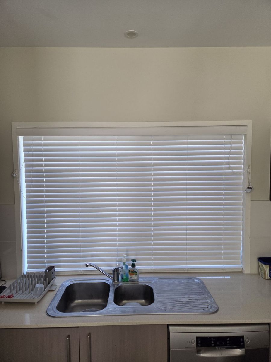 The same kitchen window with a new white venetian blind