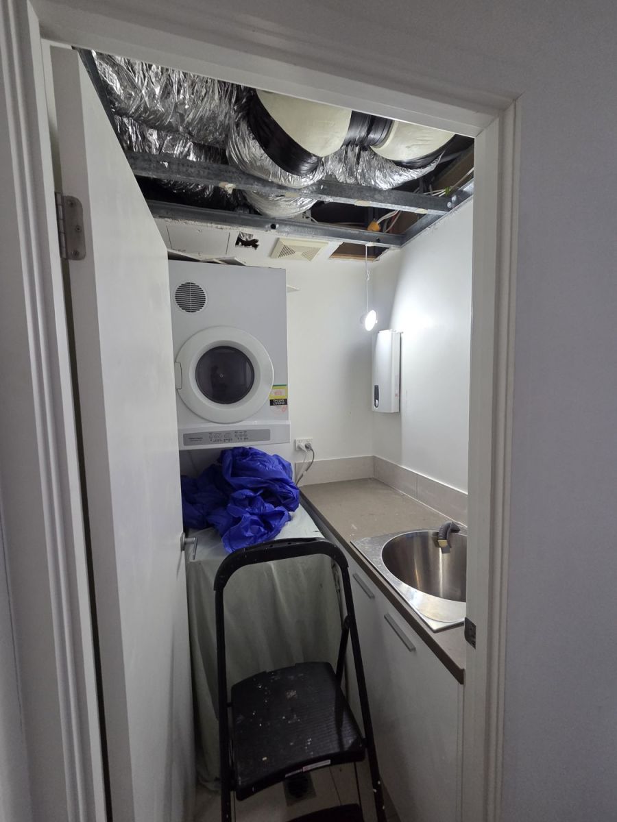 Laundry with the ceiling open and ducting showing, before